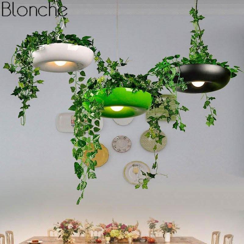 Trois suspensions blanche, verte et noire alignées au-dessus d'une table dressée