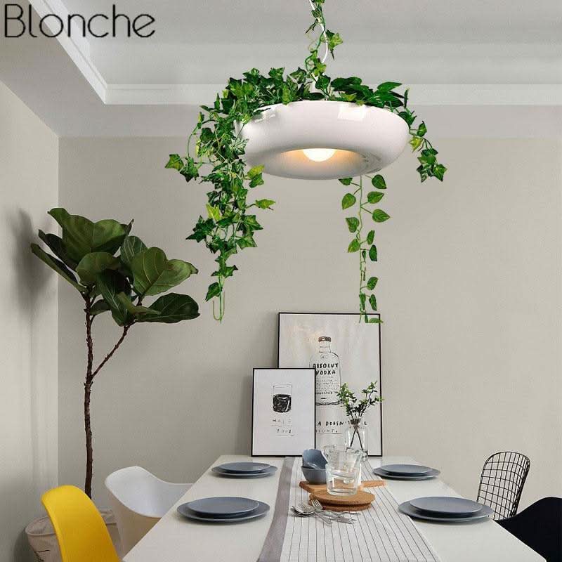 Luminaire blanc ovale suspendu au-dessus d'une table de salle à manger minimaliste