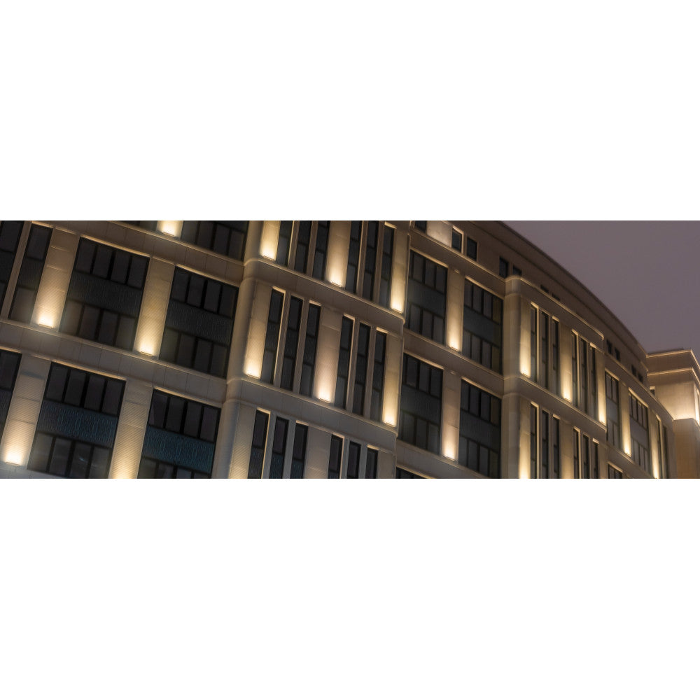 Mise en ambiance nocturne éclairant la façade d'un immeuble par bandeaux verticaux