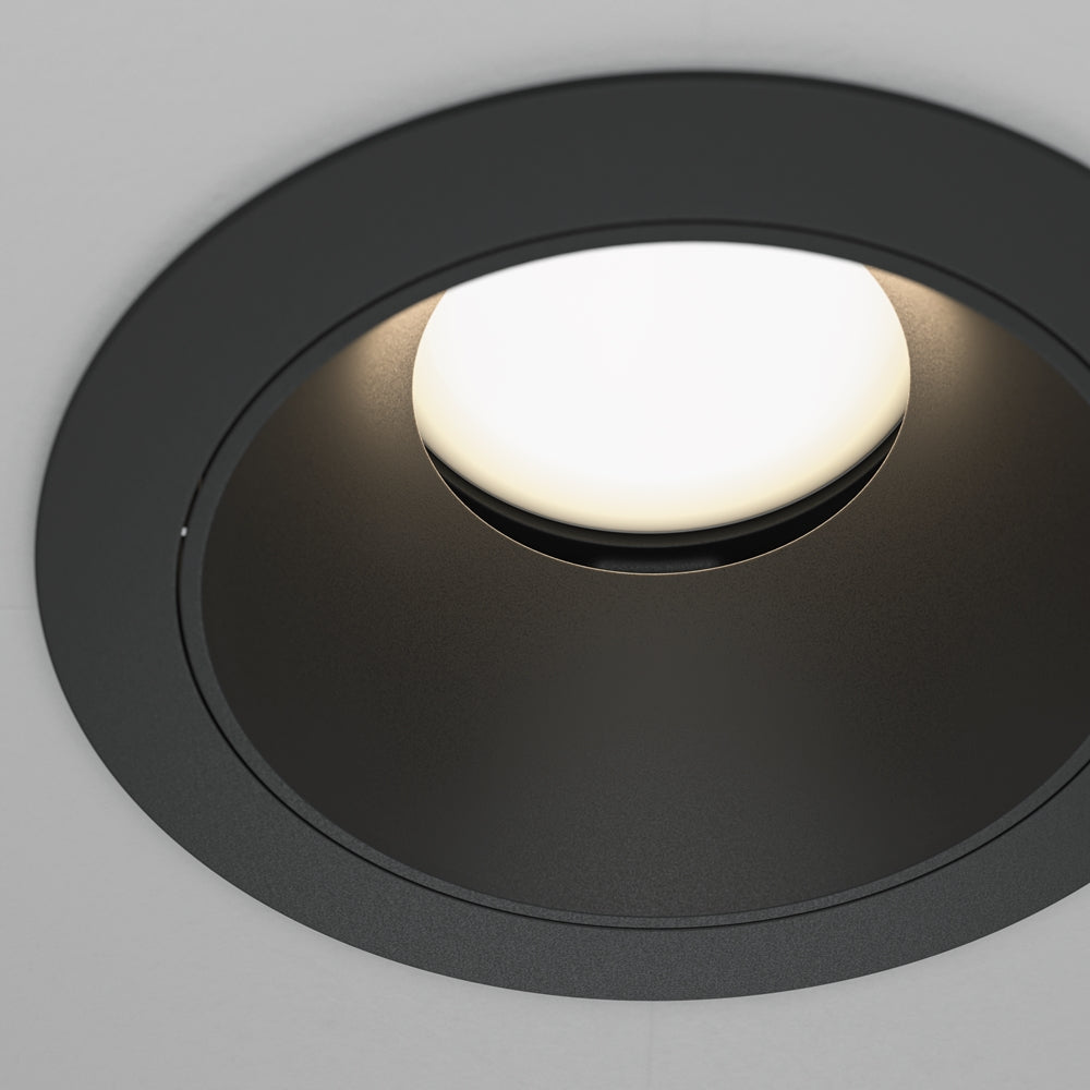 Gros plan sur la collerette noire et le diffuseur opalin illuminé