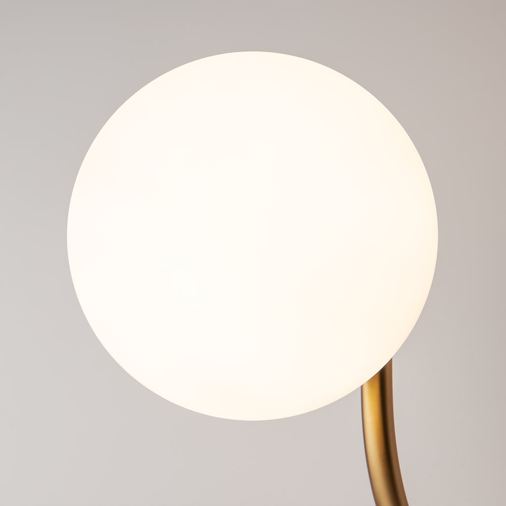 Gros plan du globe de verre opalin blanc et du départ du bras