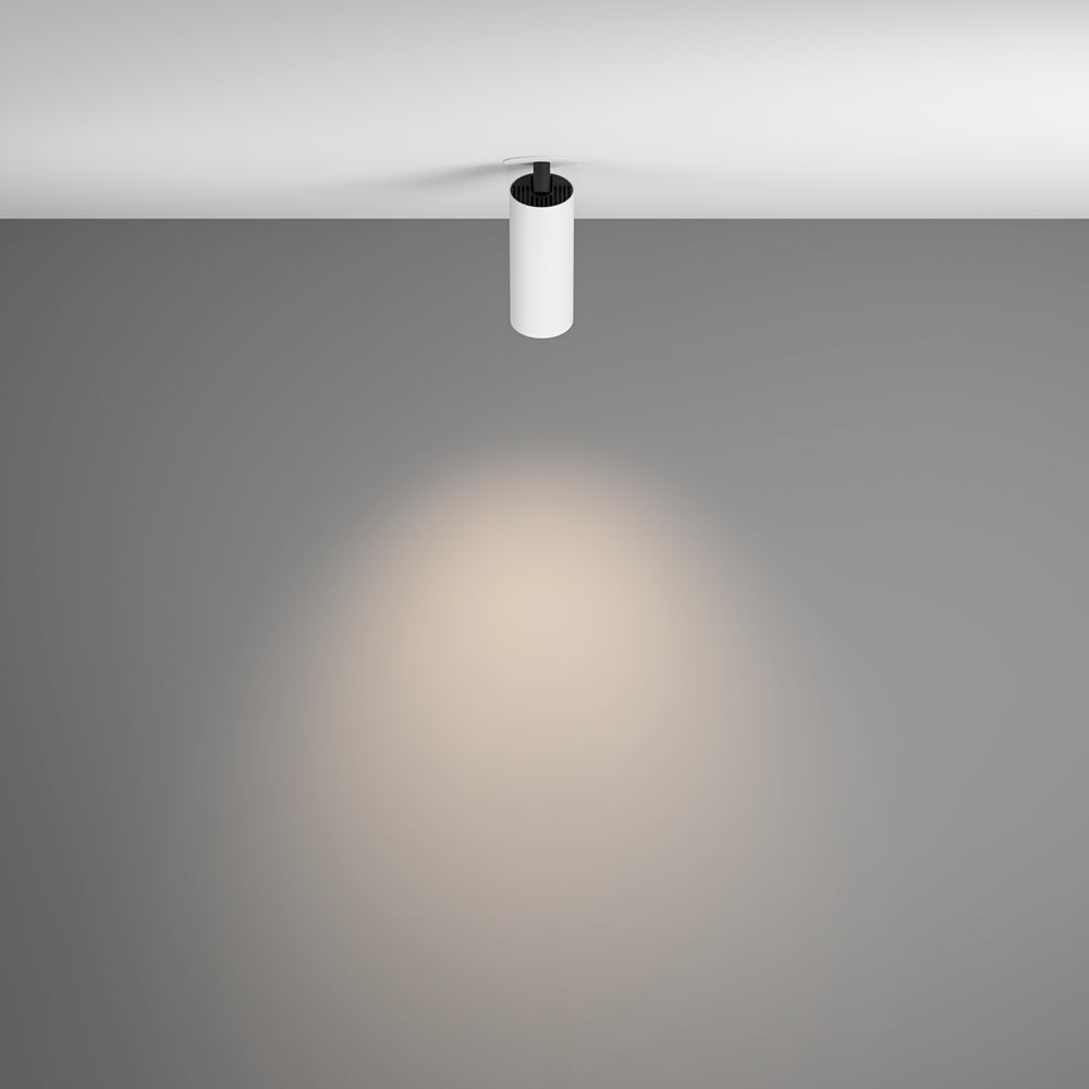 Spot blanc suspendu au plafond projetant un halo de lumière chaude