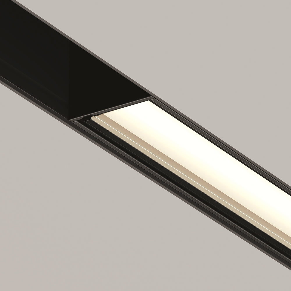 Gros plan sur la bande lumineuse blanche et le cadre noir du luminaire linéaire.
