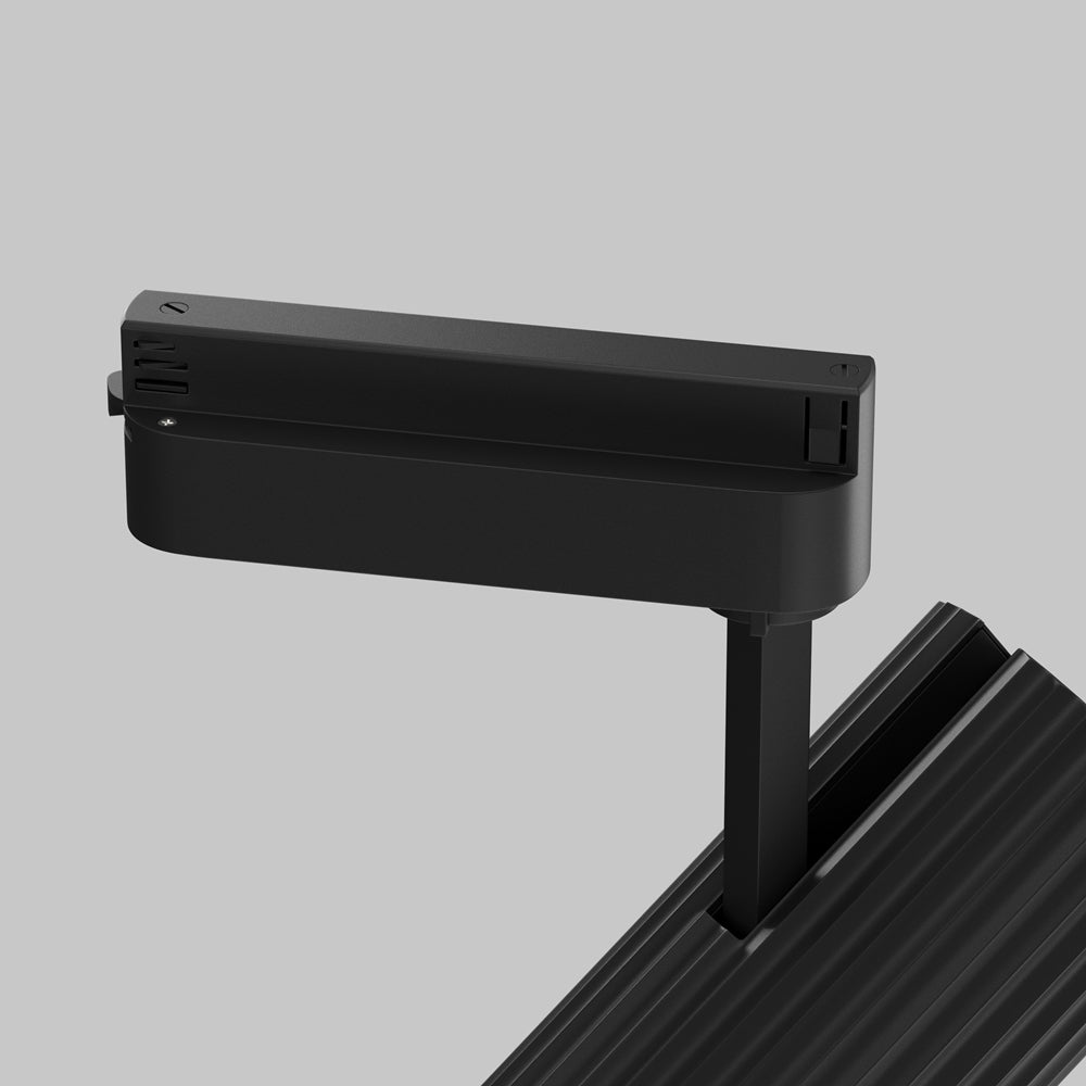 Détail du boîtier adaptateur noir clipsé sur le rail conducteur