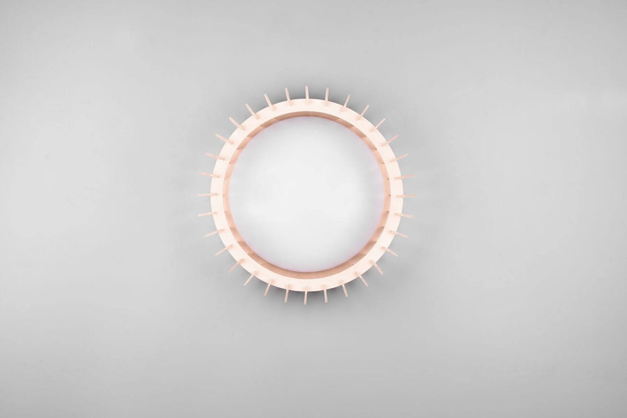 Vue frontale du plafonnier éteint, anneau crénelé beige et grand diffuseur blanc
