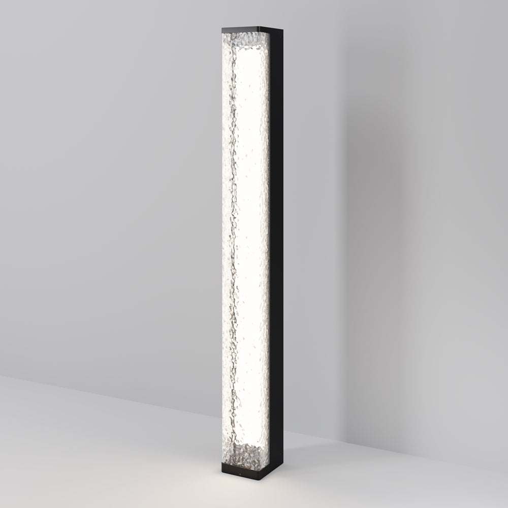 Colonne lumineuse verticale allumée, face en verre embossé, cadre noir, vue en pied