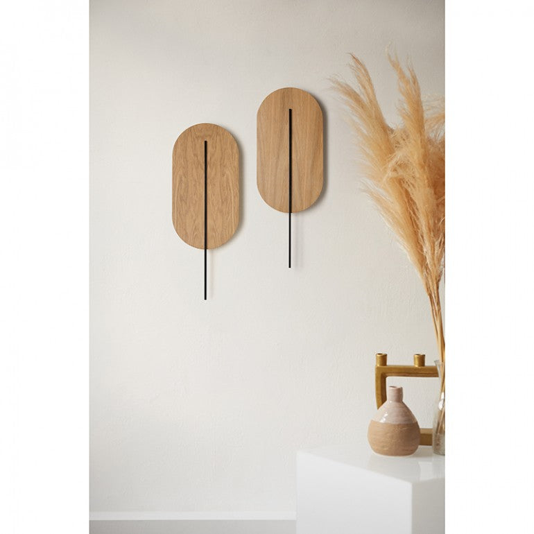 Paire d'appliques murales à tige noire installées sur un mur beige, ambiance déco