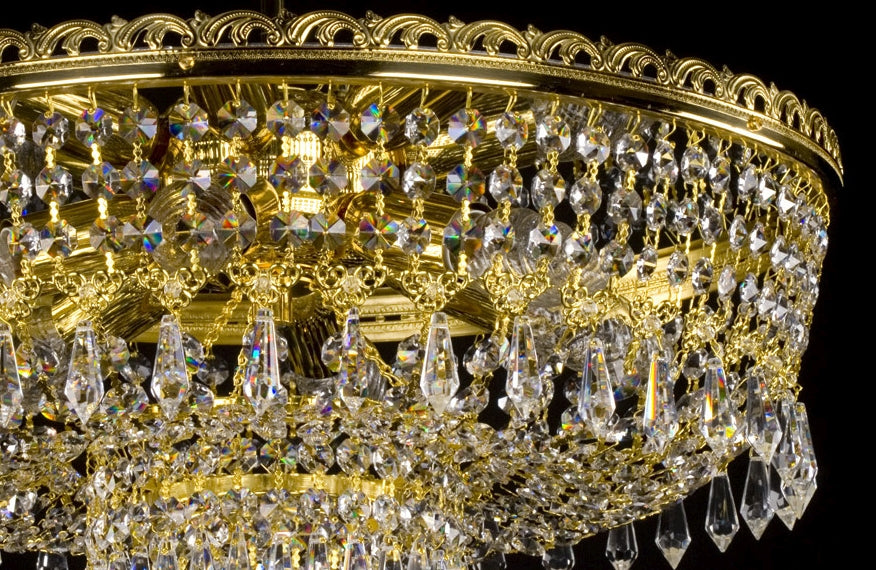 Détail de la couronne dorée ajourée et des guirlandes de cristal suspendues