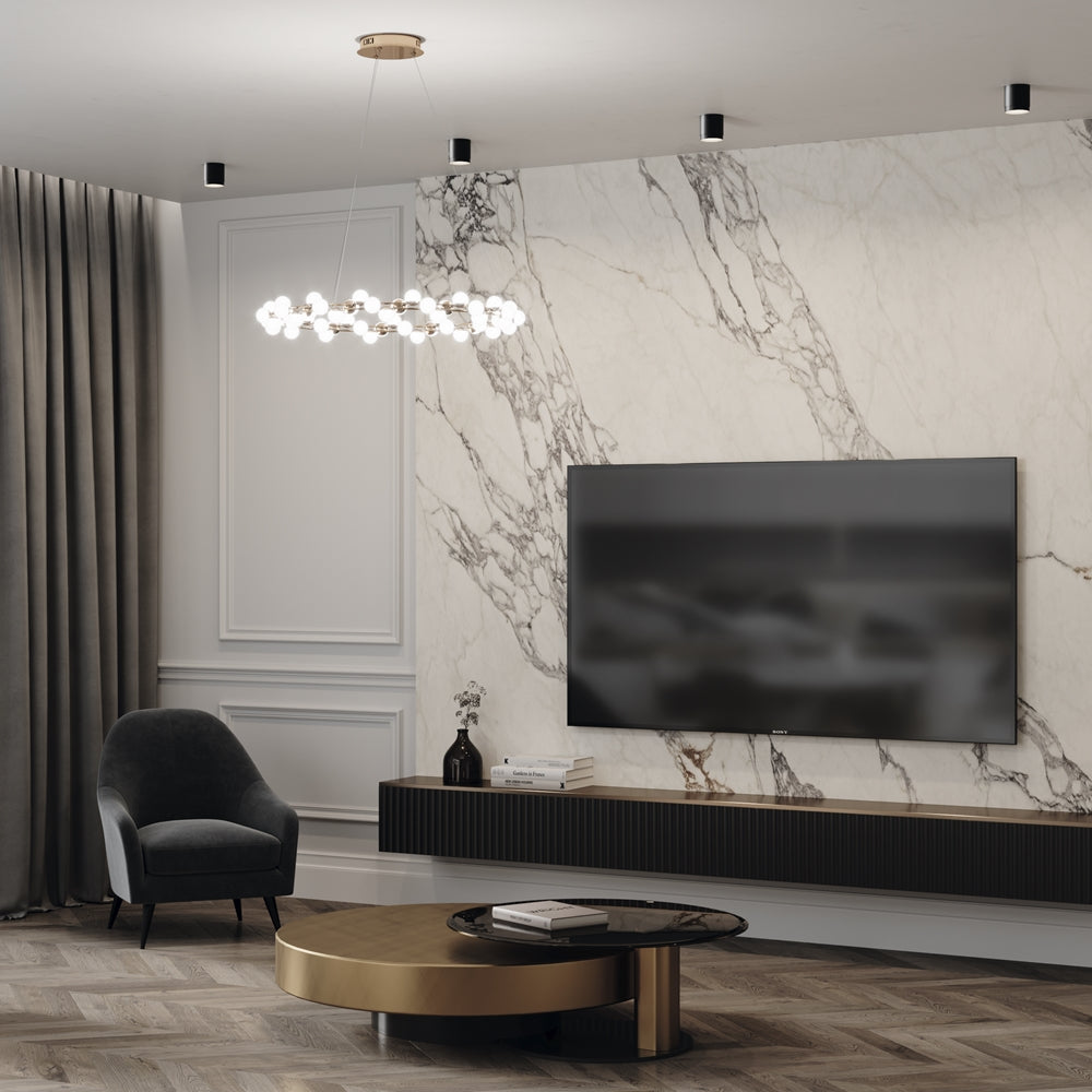 Salon contemporain avec plusieurs plafonniers noirs cylindriques et un grand lustre