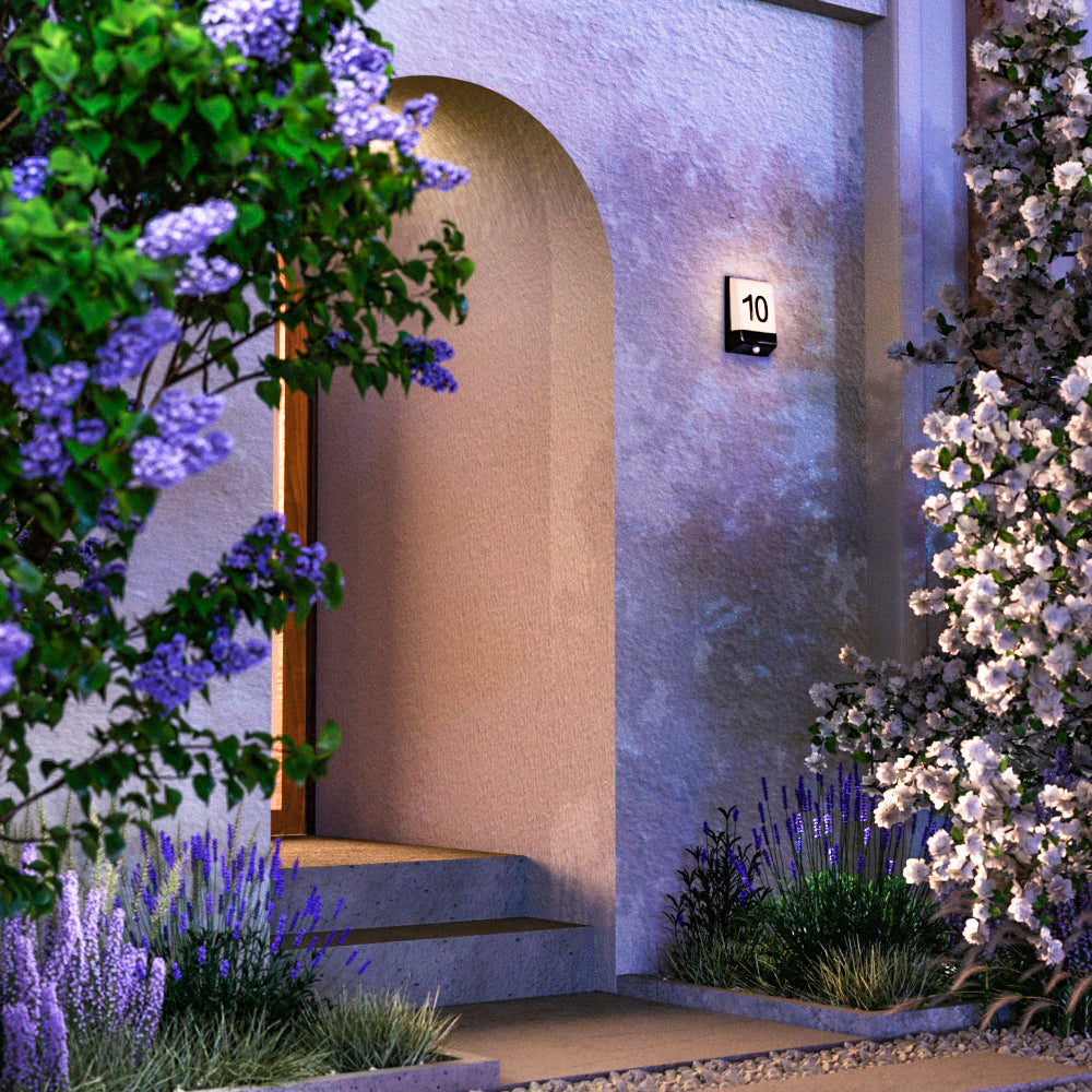Mise en ambiance extérieure de nuit, applique murale numéro 10 près d'une porte