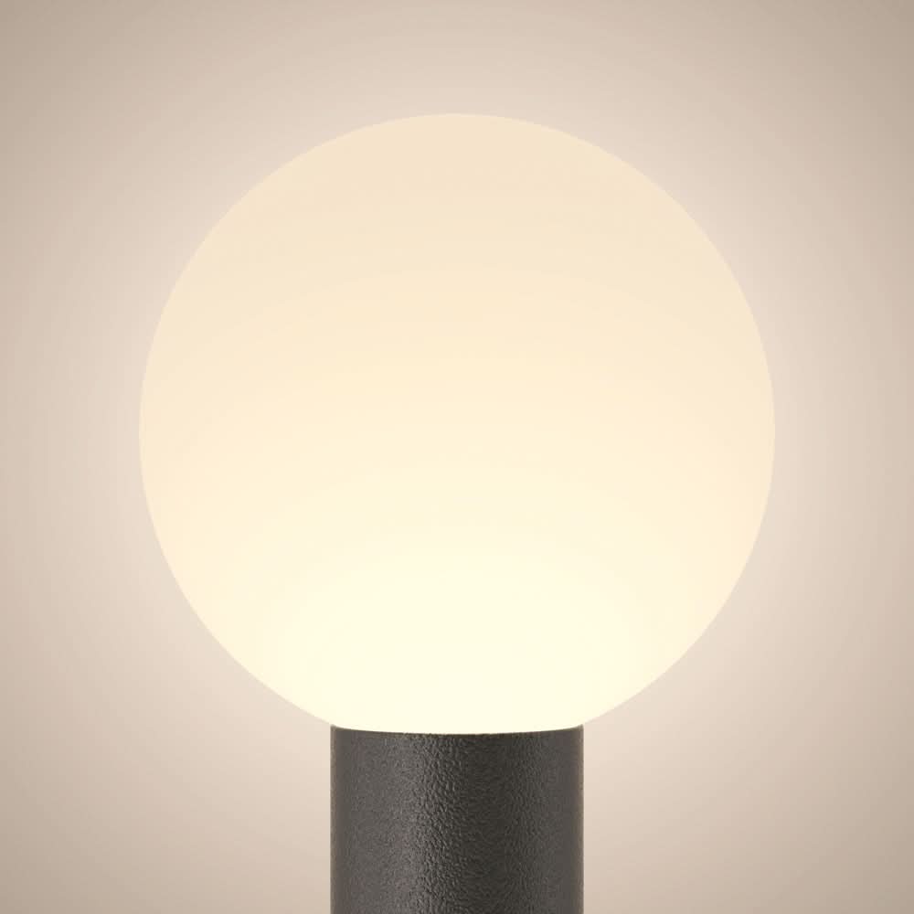Plan serré sur le globe lumineux diffusant un halo chaud et doux