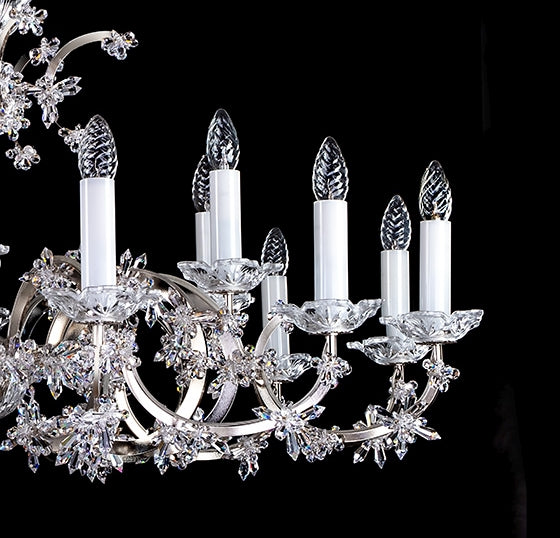 Vue rapprochée des bras, coupelles et bougies blanches du lustre