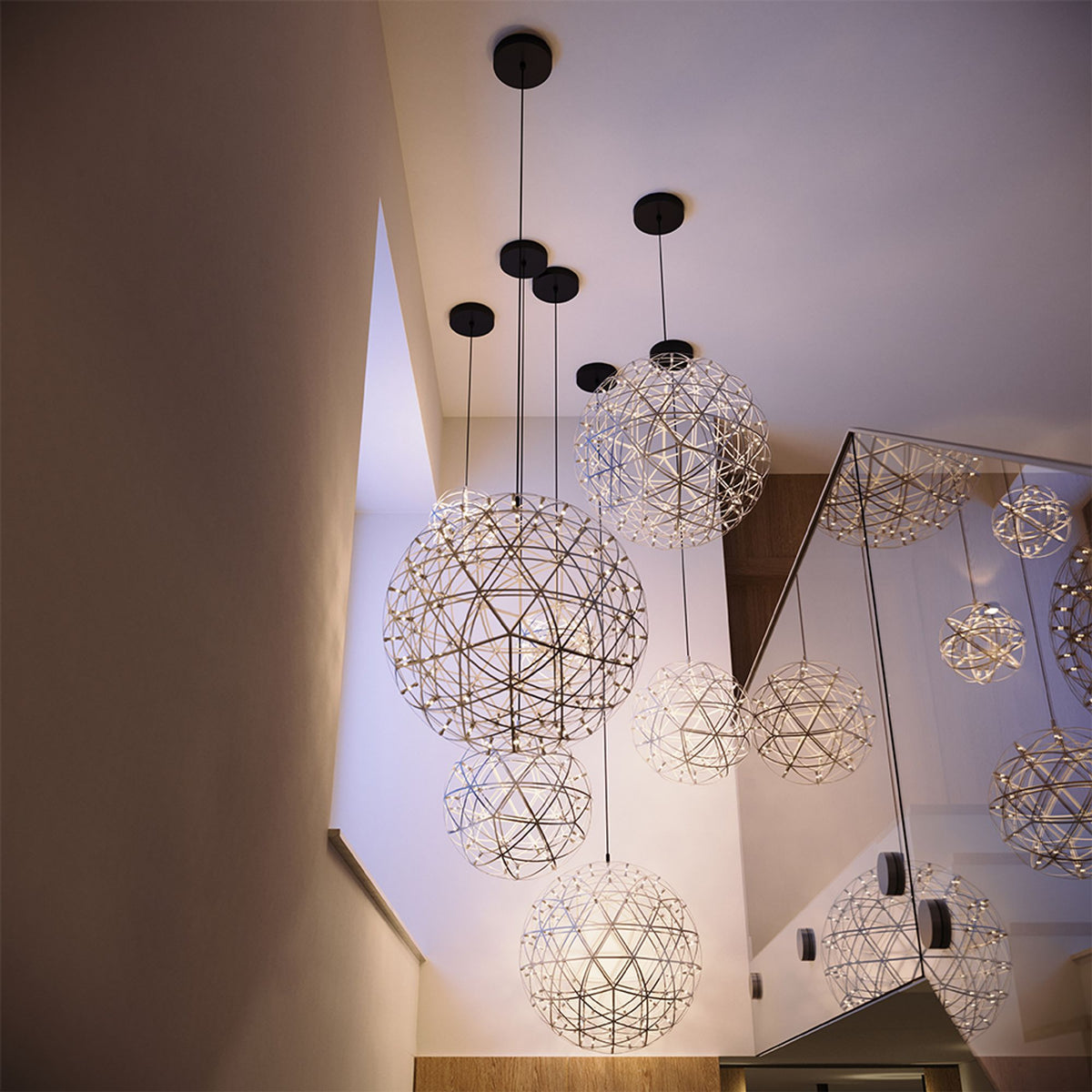Vue en contre-plongée de plusieurs suspensions sphériques fixées au plafond blanc.