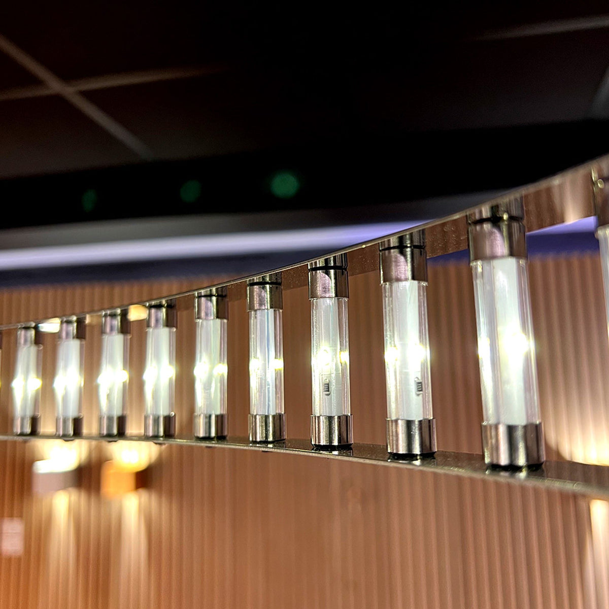 Détail rapproché des ampoules LED cylindriques réparties sur le bandeau métallique