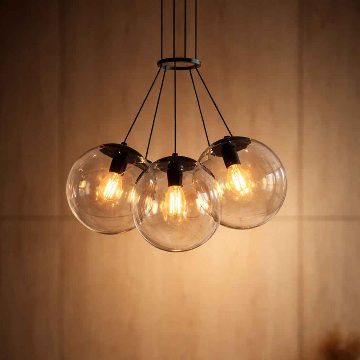 Gros plan sur les trois globes transparents et les ampoules filaments allumées
