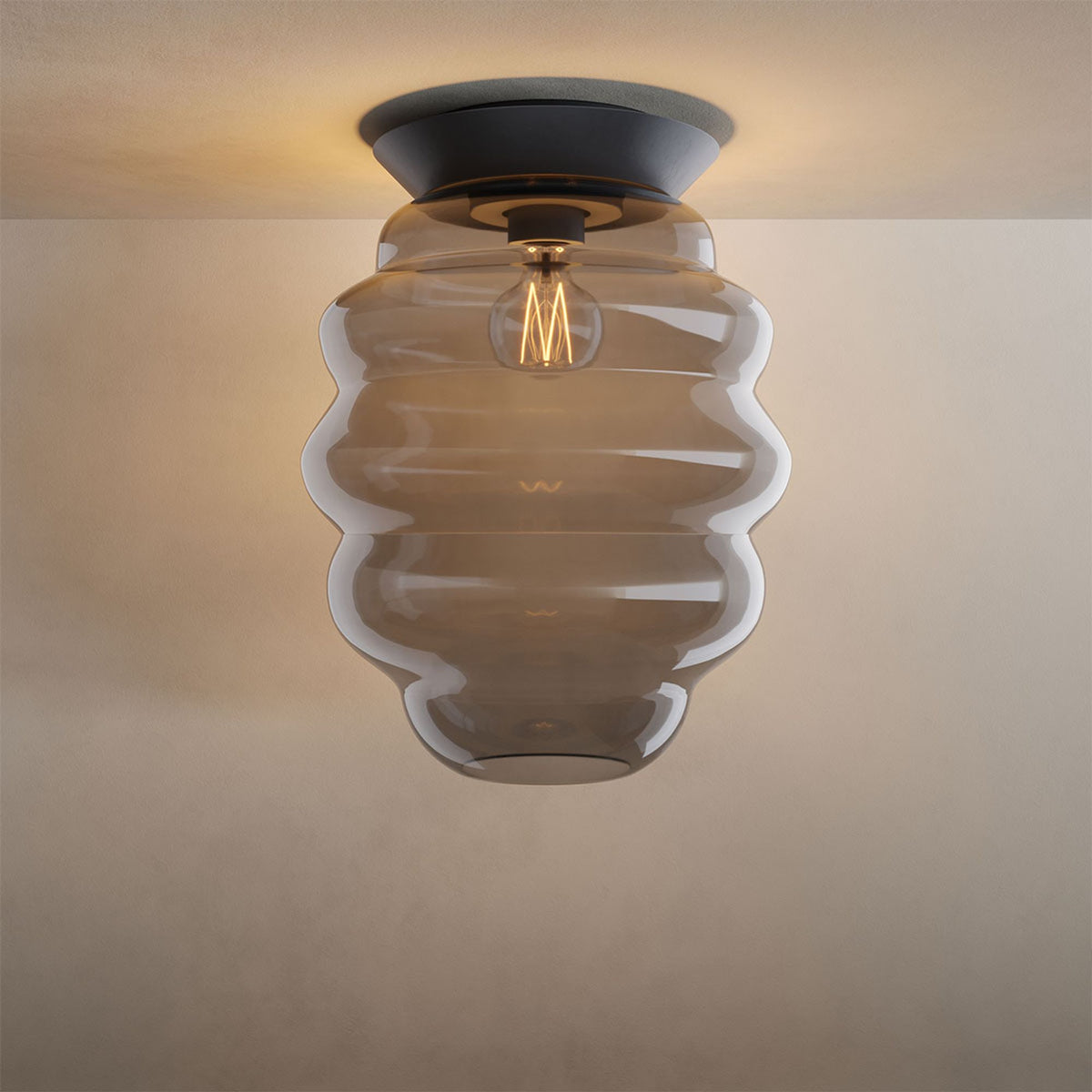 Variante en verre fumé gris, de face, montrant les stries horizontales du diffuseur.