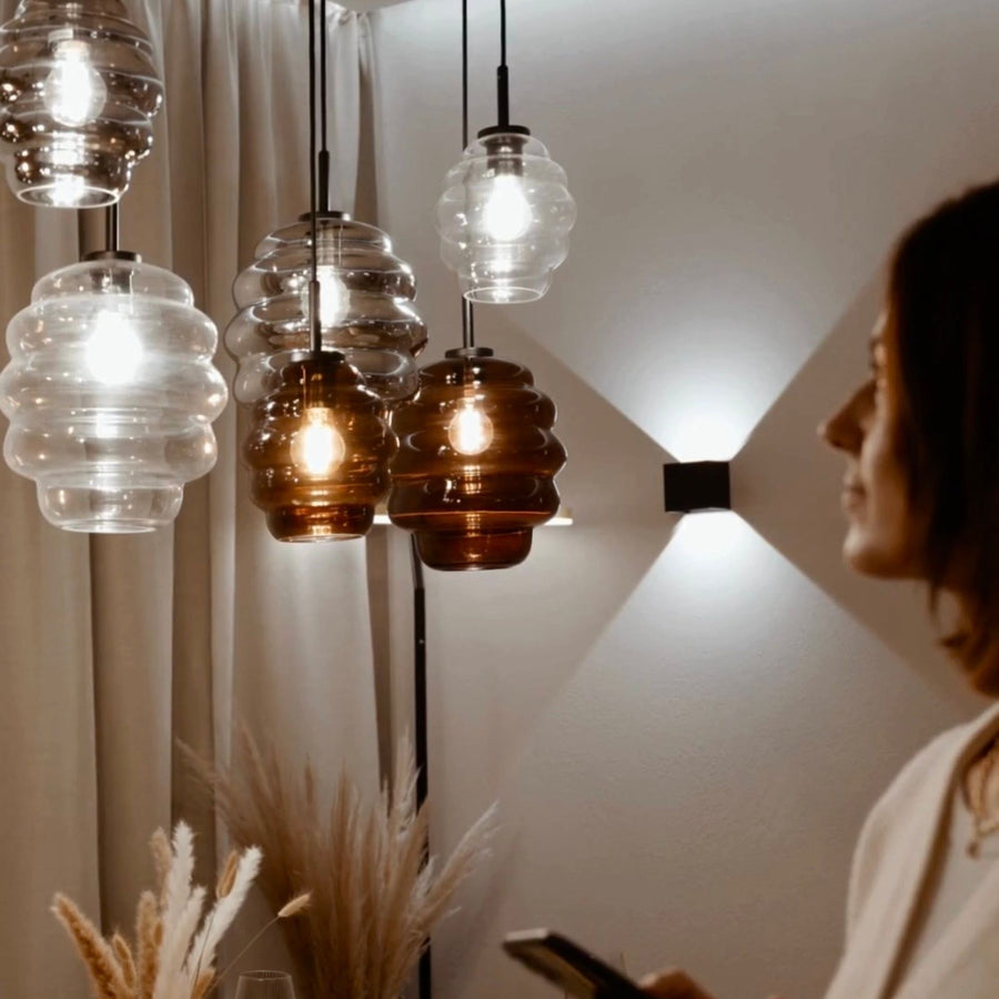 Gros plan sur les verres côtelés transparents et ambrés, personne de profil à droite