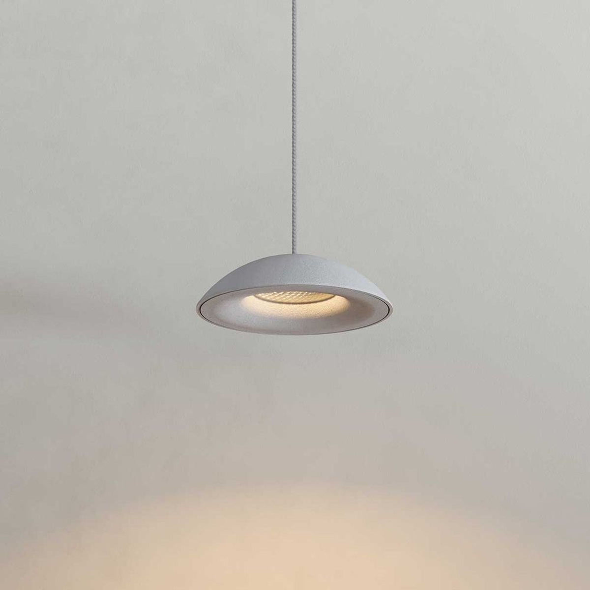 Gros plan sur un abat-jour blanc demi-sphérique éclairé par une LED intégrée