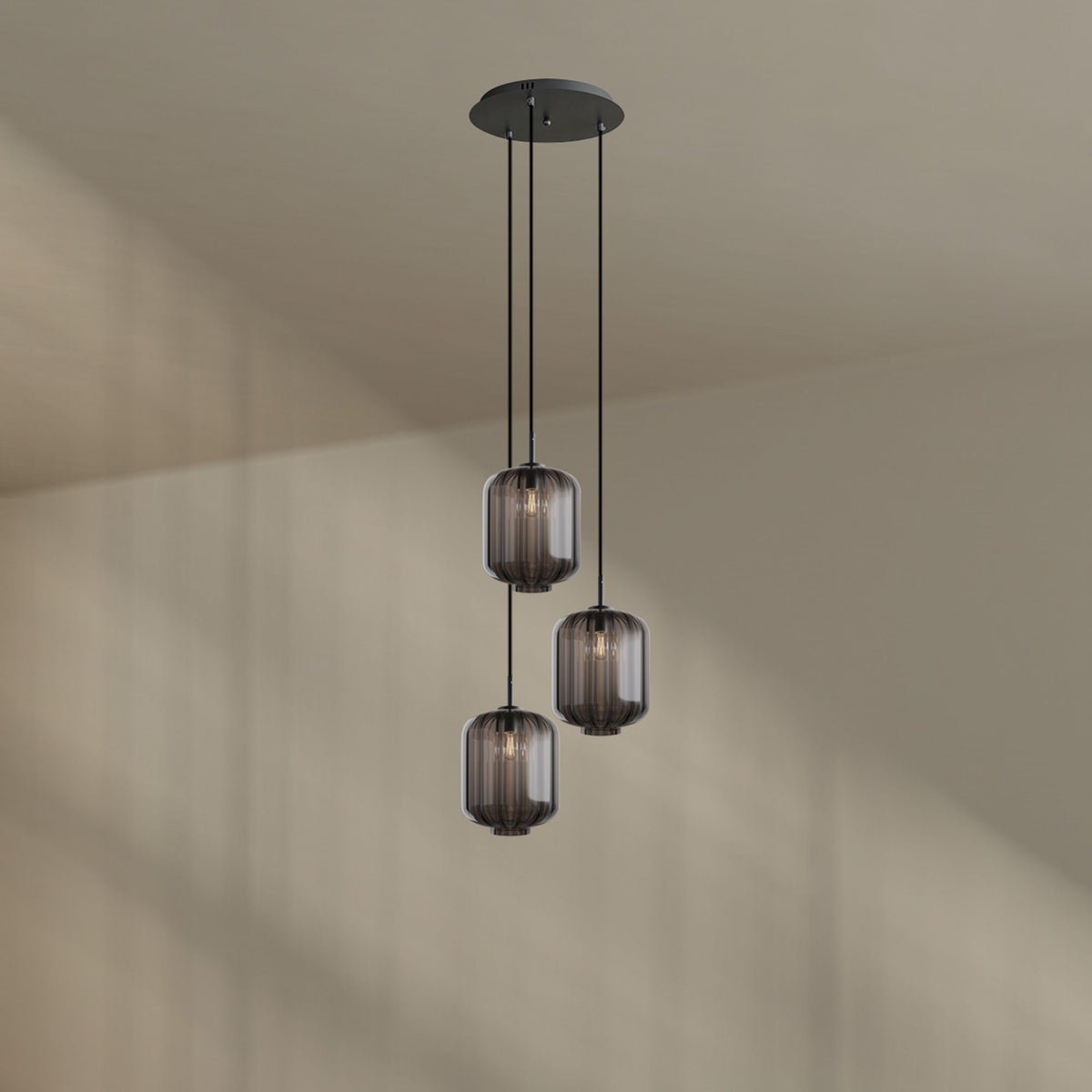 Suspension trois lumières en verre fumé gris photographiée seule sur fond clair