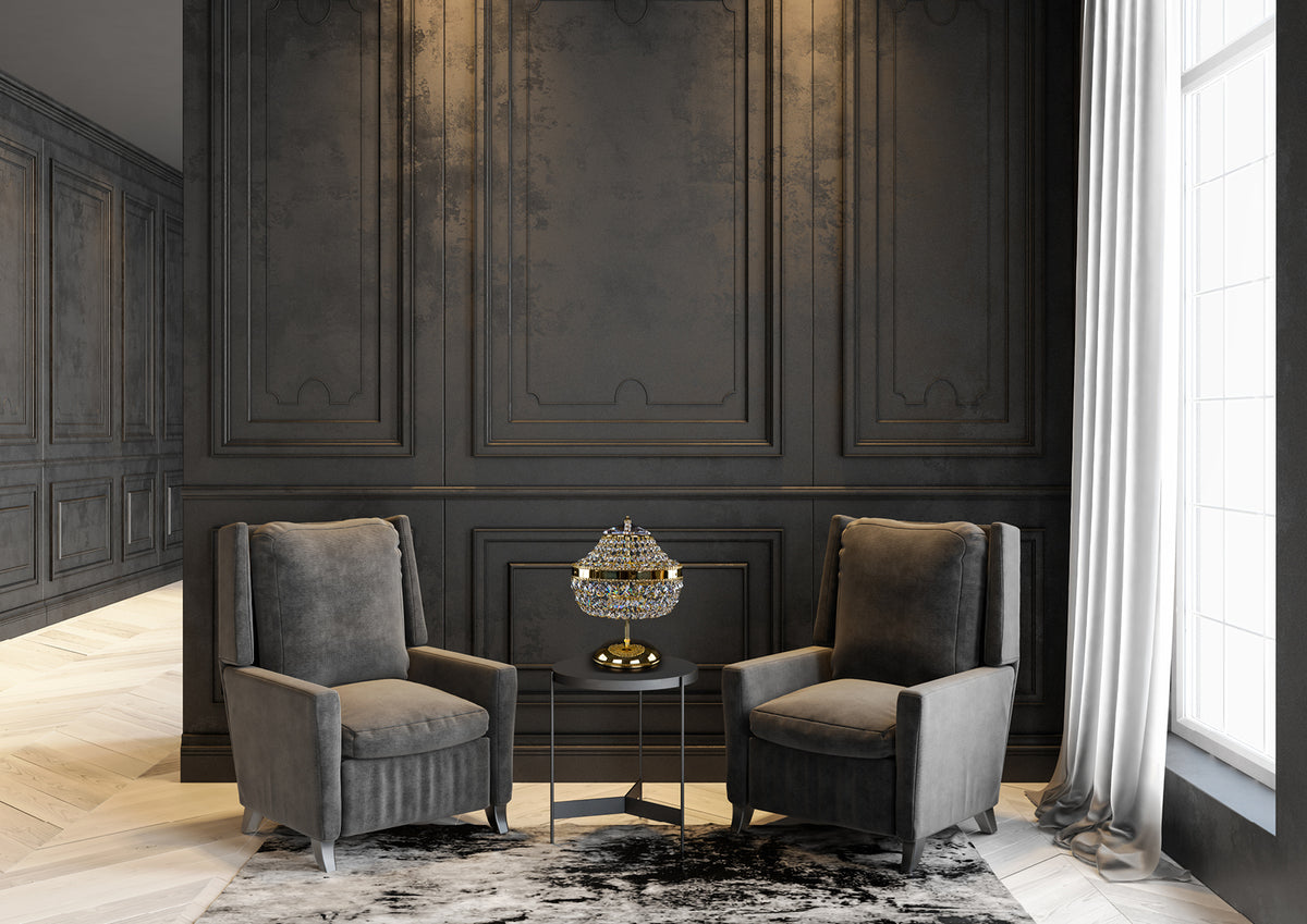 Mise en ambiance : lampe posée sur table basse entre deux fauteuils, mur sombre mouluré.