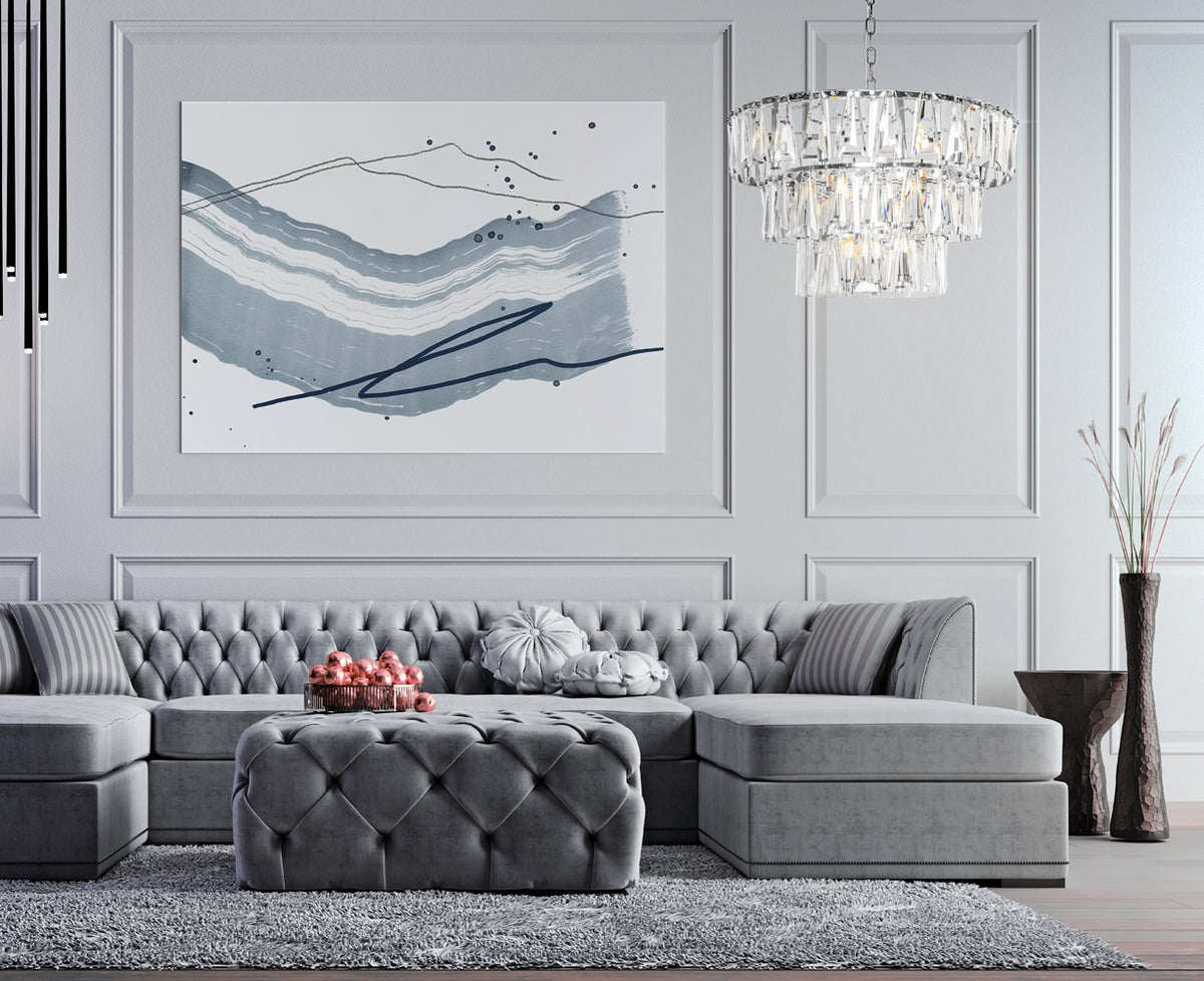 Mise en ambiance salon gris avec le luminaire suspendu au-dessus d'un canapé capitonné