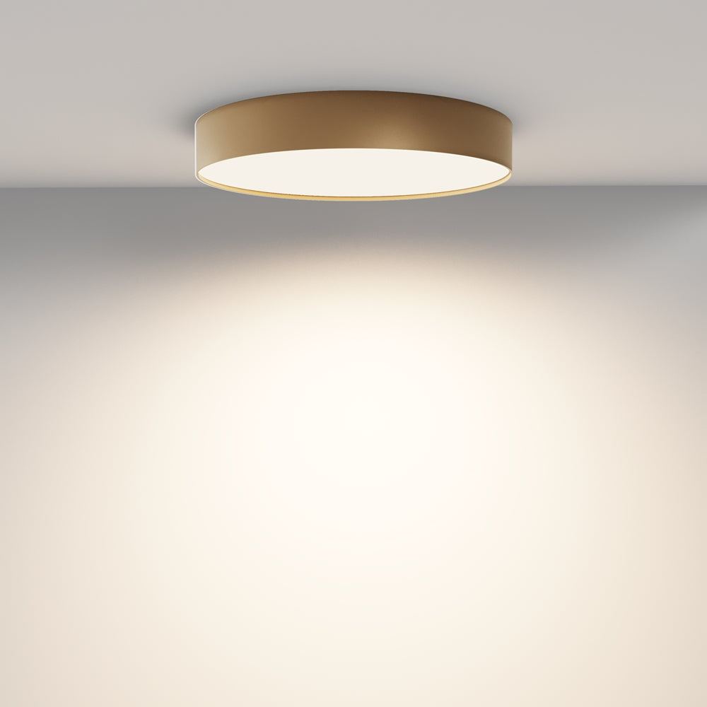 Vue de dessous du plafonnier allumé, halo lumineux diffusé sur le mur