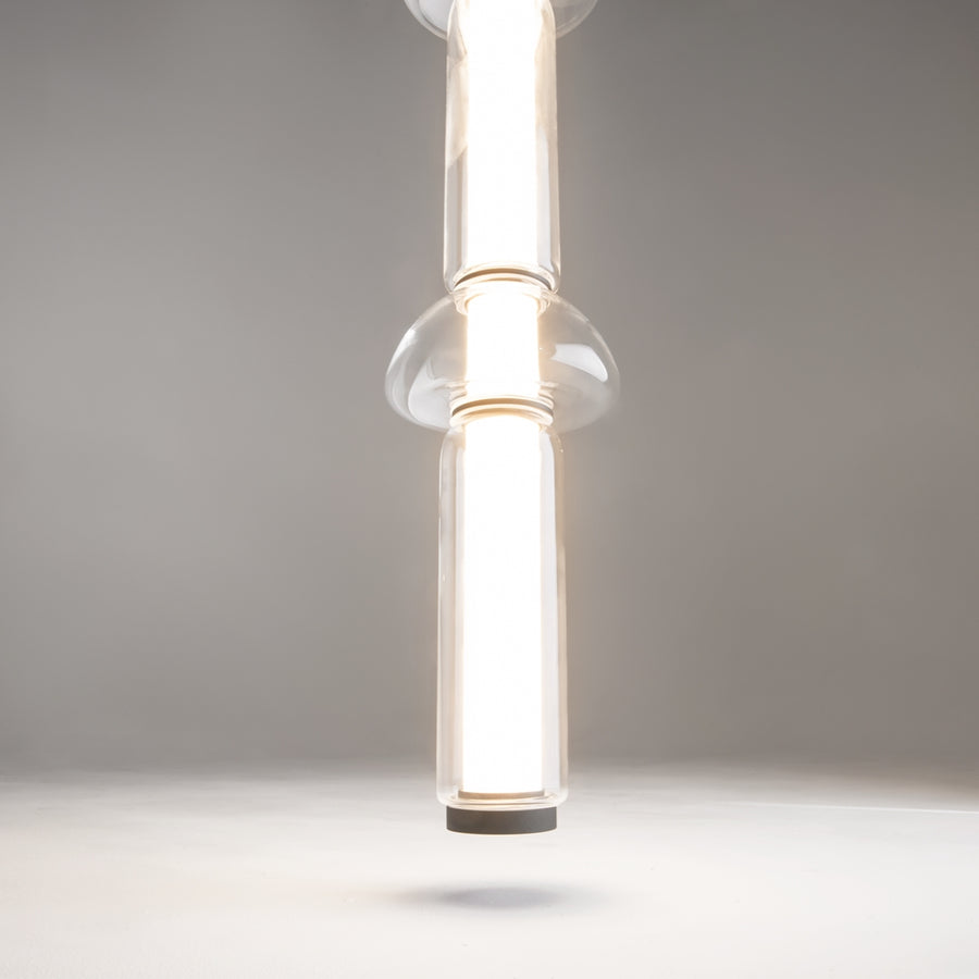 Gros plan sur un disque de verre traversé par le tube éclairé