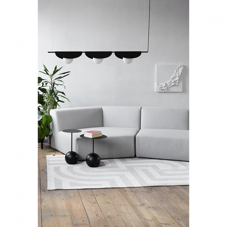 Intérieur contemporain, luminaire noir suspendu devant un canapé gris clair