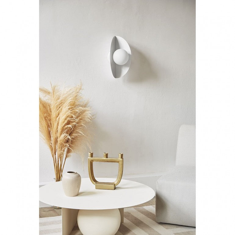 Mise en ambiance d'une applique murale blanche au-dessus d'une table basse claire