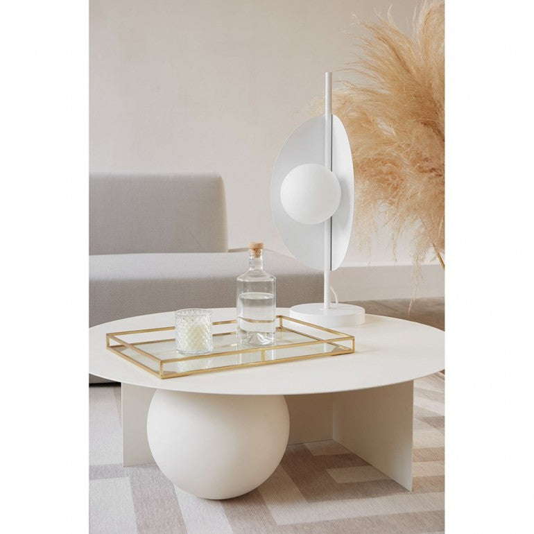 Mise en ambiance : lampe posée sur table basse blanche près d'un vase