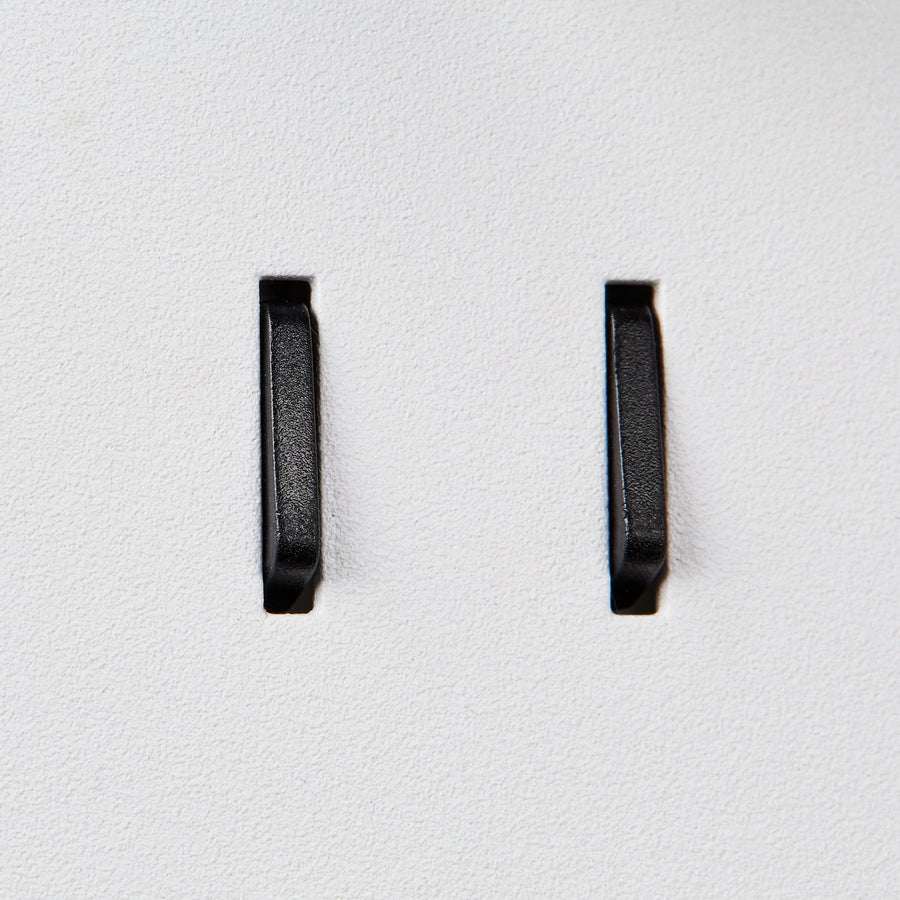 Détail des deux interrupteurs noirs sur la platine murale blanche.