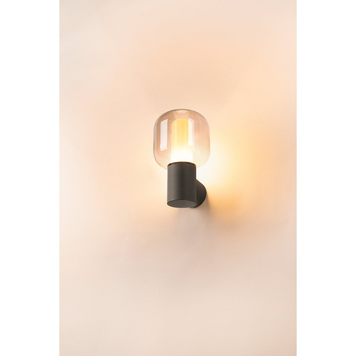 Mise en ambiance sur mur clair, halo chaud diffusé par l'applique extérieure.