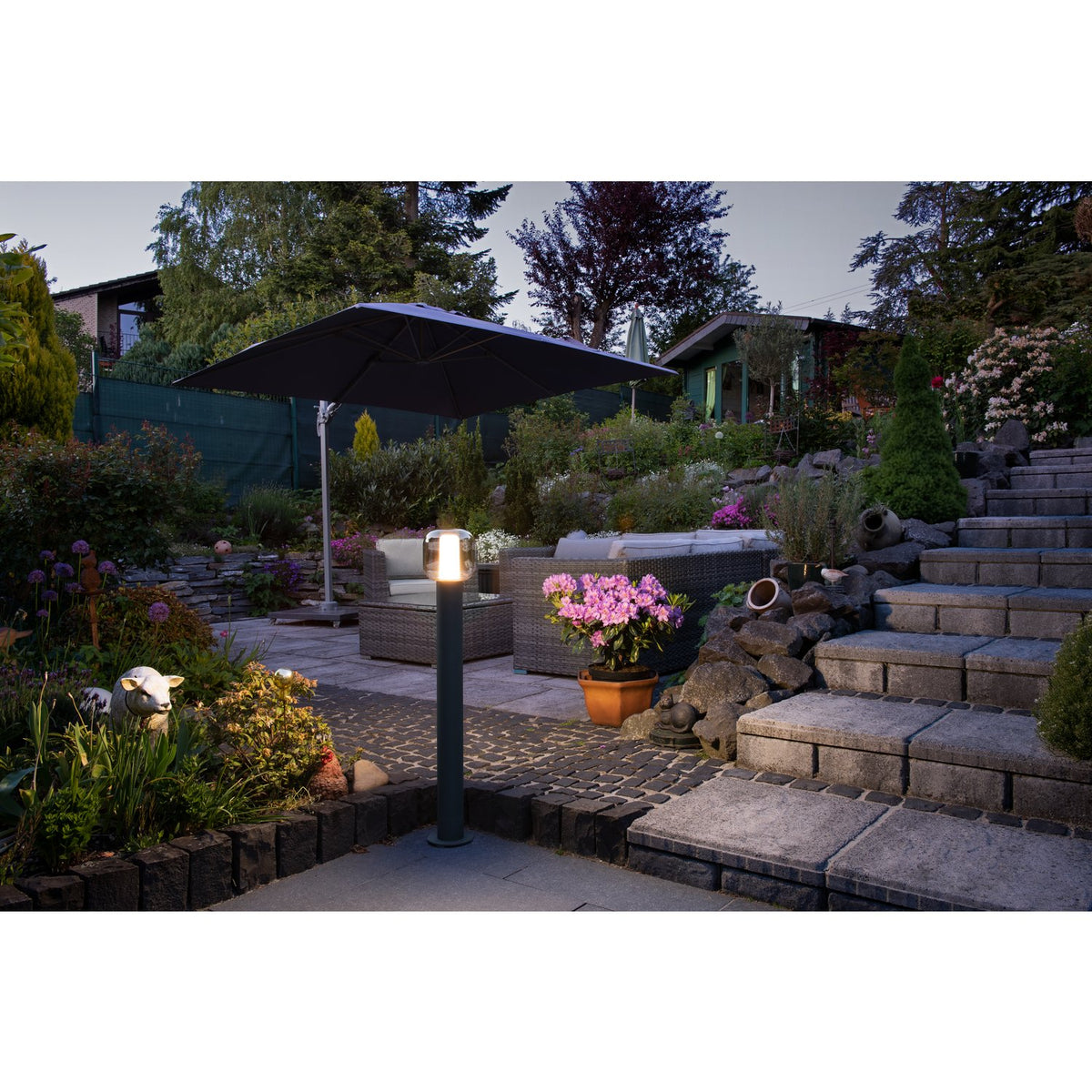 Mise en ambiance nocturne du lampadaire dans un jardin avec terrasse et escaliers