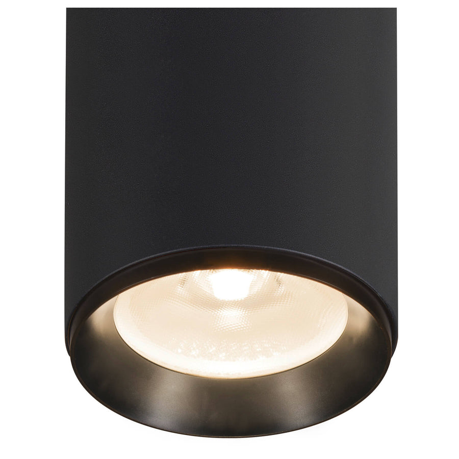Gros plan du bas du cylindre noir avec lentille LED allumée et réflecteur.