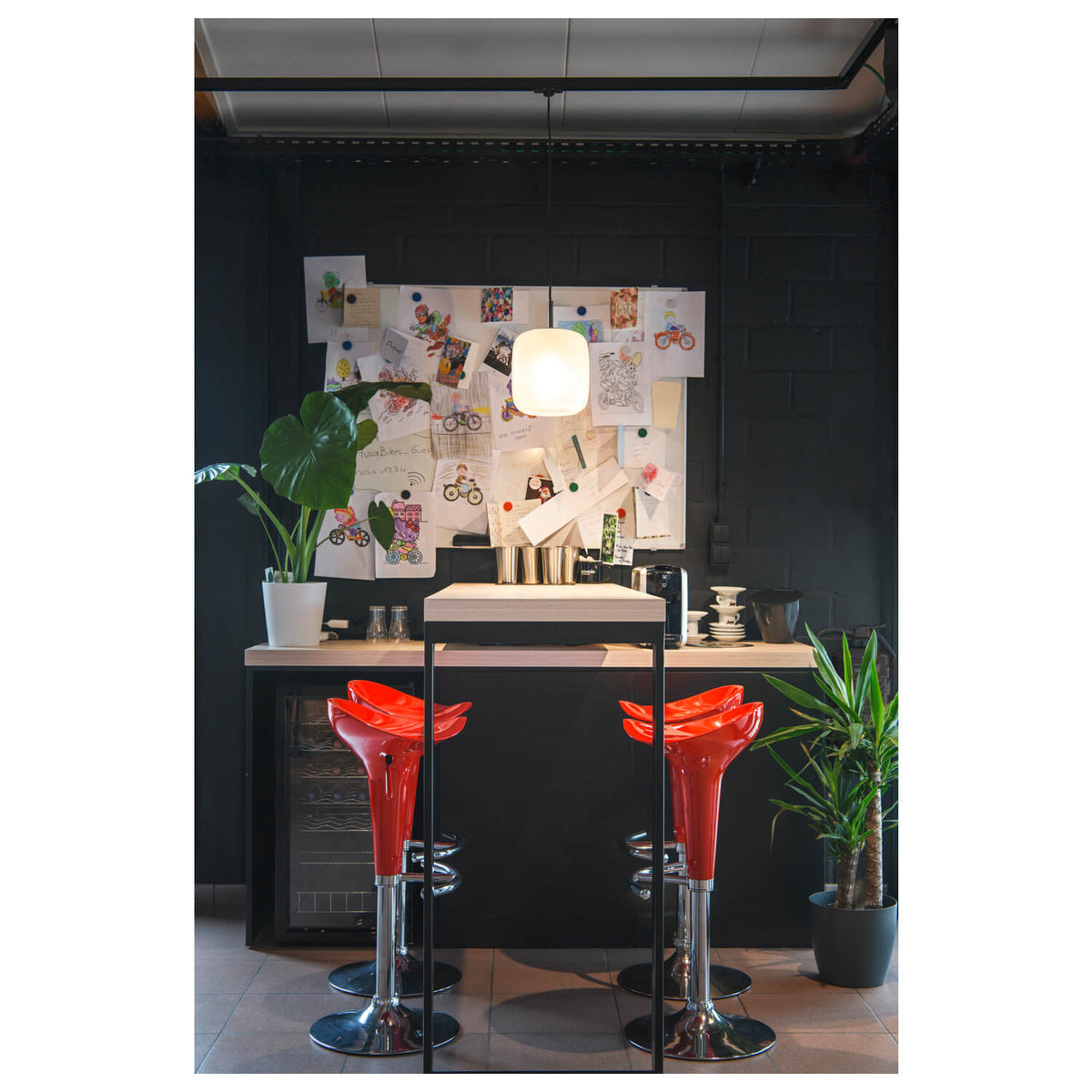 Mise en ambiance au-dessus d'un comptoir de bar, suspension blanche allumée.