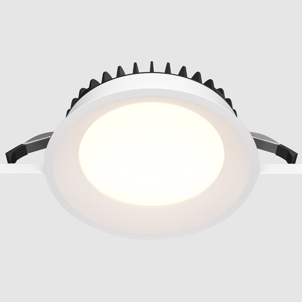 Spot rond encastré vu de dessous, ailettes noires et ressorts de fixation apparents