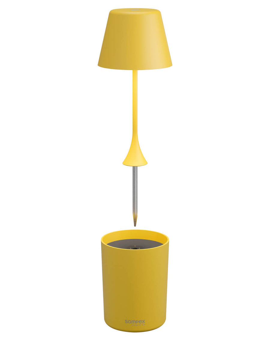 Tige détachée avec pointe métallique au-dessus du socle cylindrique jaune.