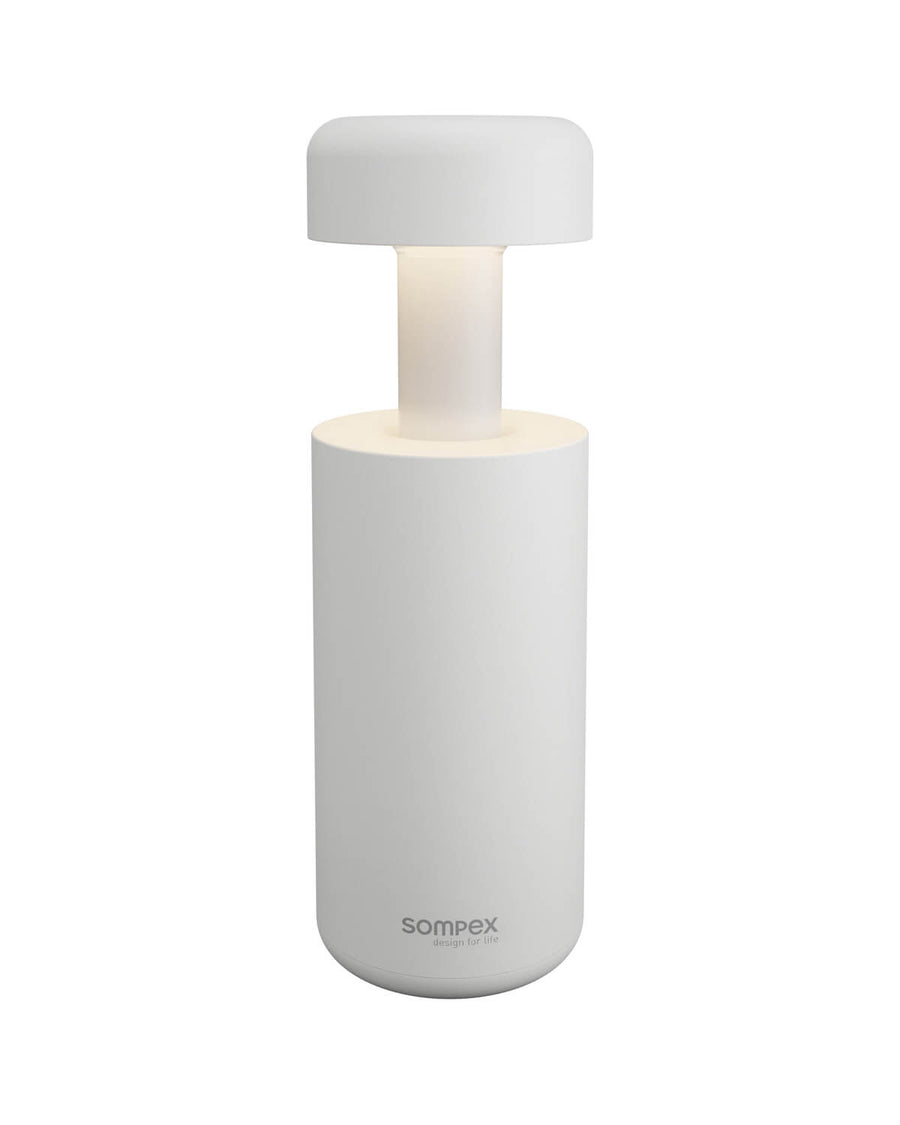 Lampe blanche de face, corps cylindrique, tige lumineuse et chapeau arrondi sur fond neutre.