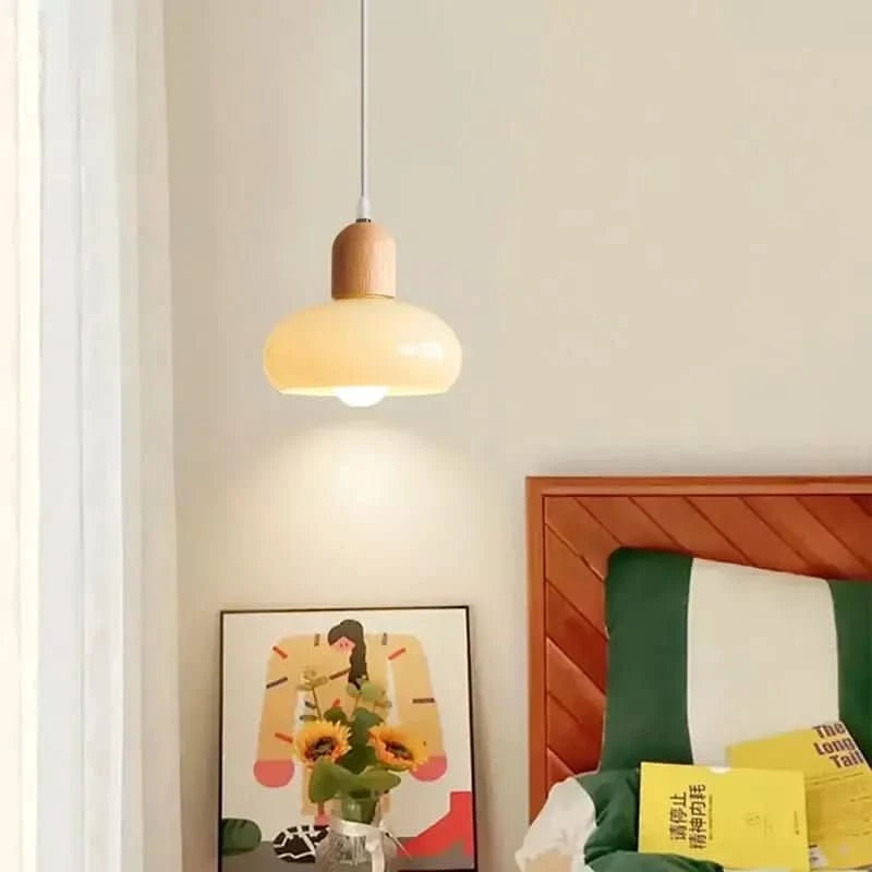 Petit luminaire suspendu près d'une table de nuit, lit en bois vert