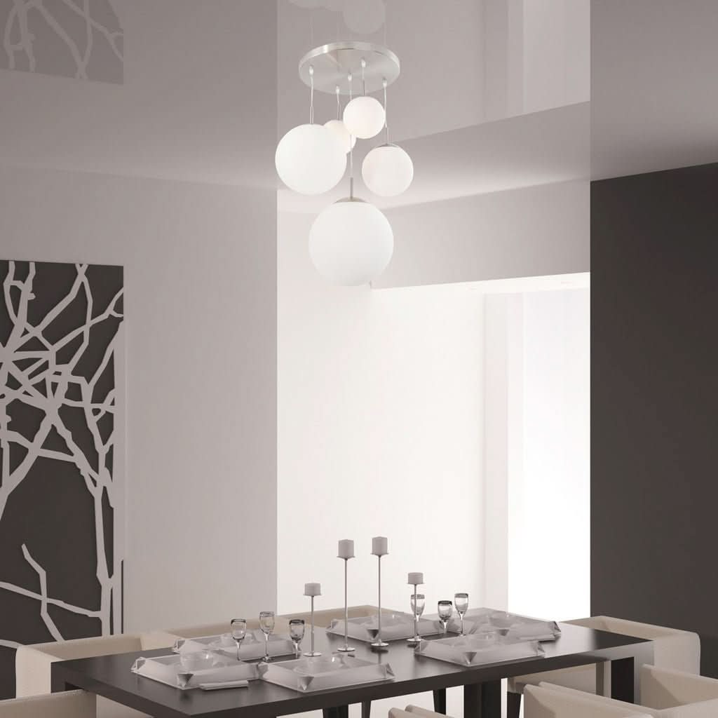 Suspension à cinq globes blancs éclairant une salle à manger moderne
