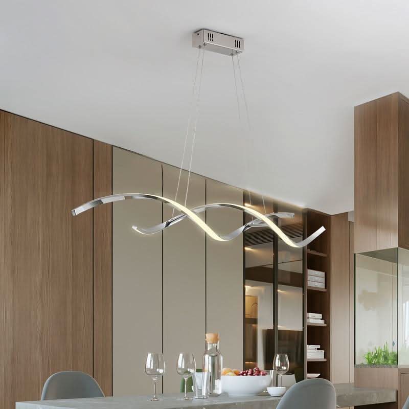 Version chromée argentée suspendue devant des façades bois, table dressée avec verres et fruits