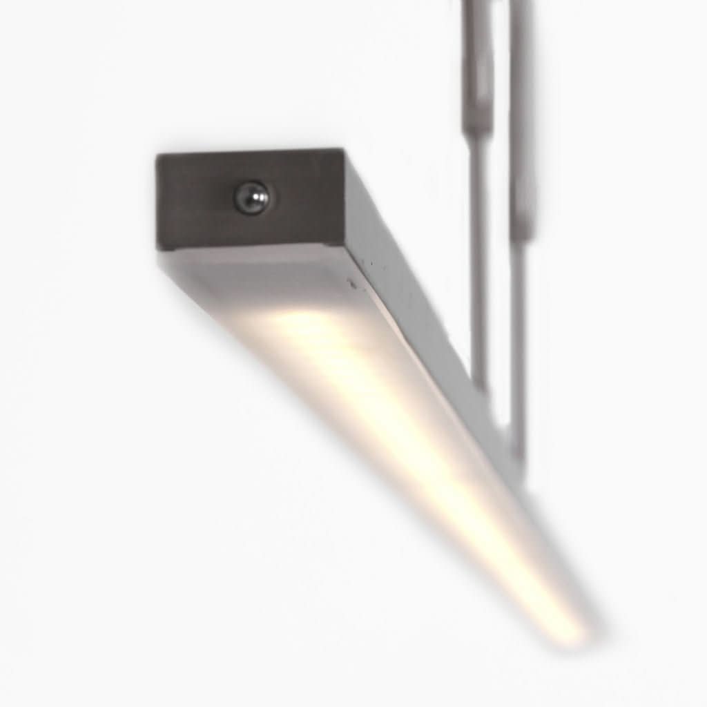 Détail de l'extrémité du bandeau lumineux avec vis apparente et éclairage LED allumé.