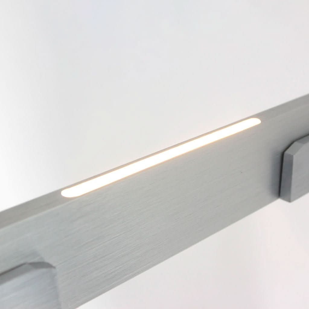 Détail de la finition brossée et de la bande LED allumée sous le profil.