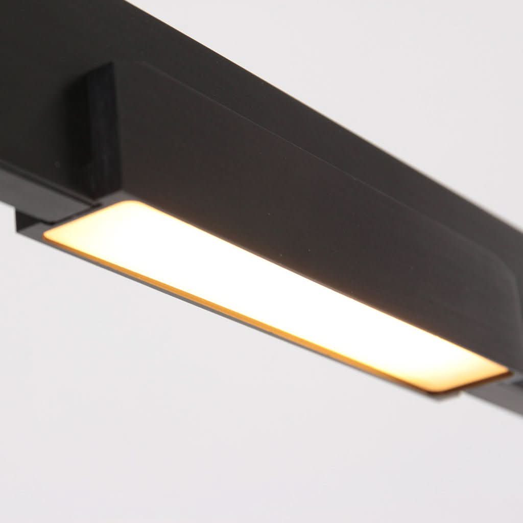 Détail rapproché du diffuseur LED allumé sous la barre noire brossée