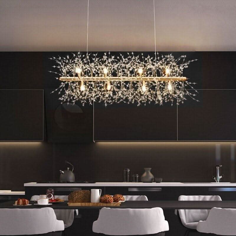 Grande suspension dorée allumée au-dessus d'une table de salle à manger moderne