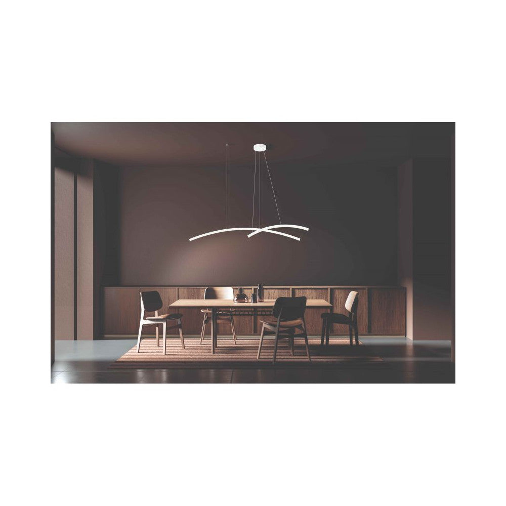 Suspension allumée au-dessus d'une table de salle à manger, éclairant la pièce sombre.
