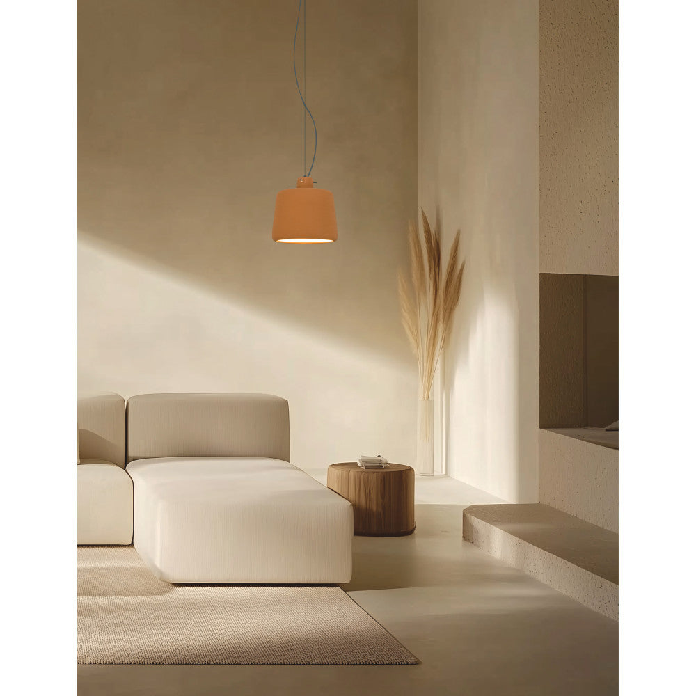 Mise en ambiance salon avec suspension orange allumée au-dessus d'un canapé beige