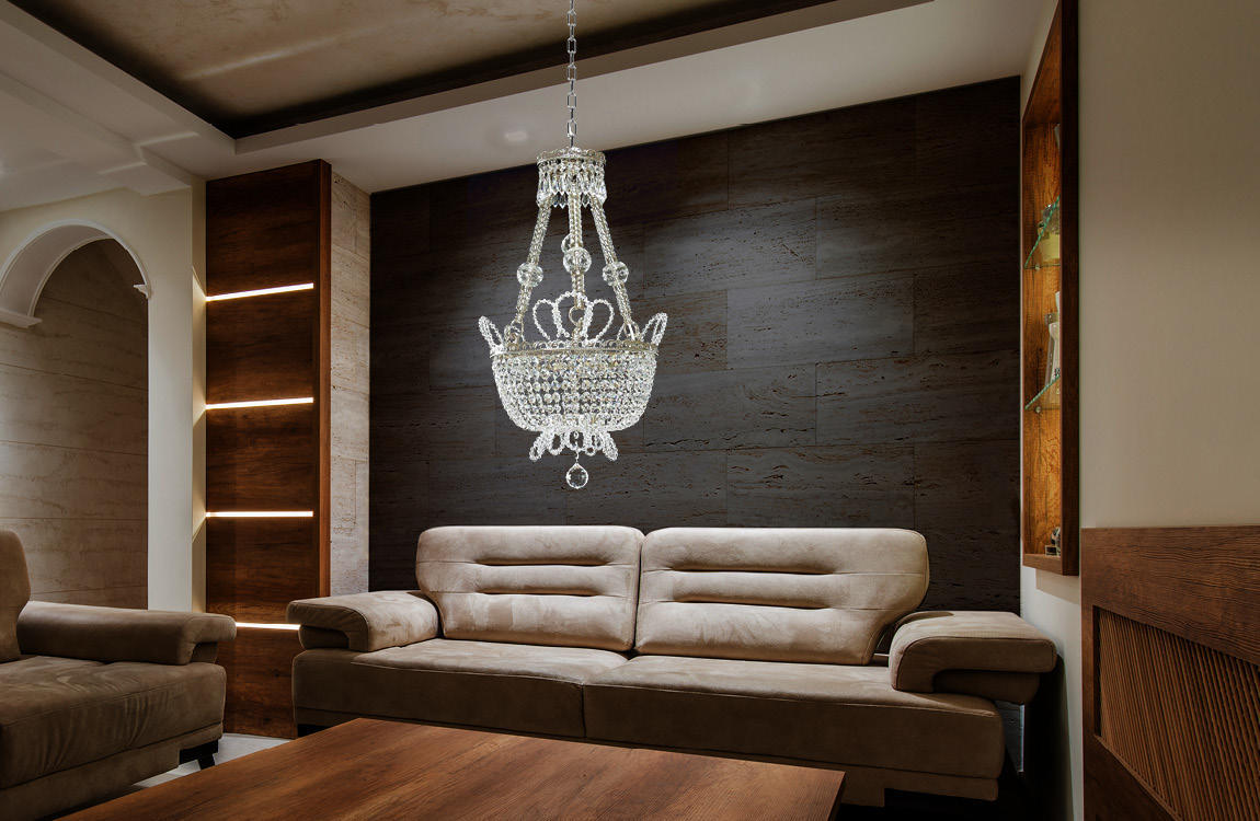 Lustre en cristal installé au-dessus d'un canapé dans un salon au mur sombre