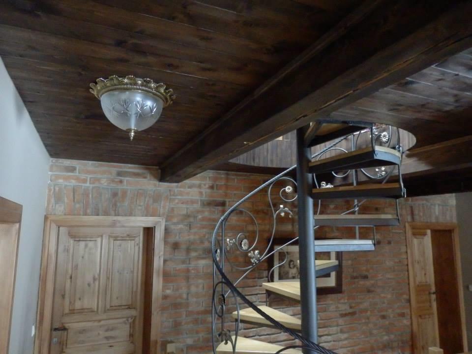 Luminaire installé au plafond en bois, près d'un escalier hélicoïdal
