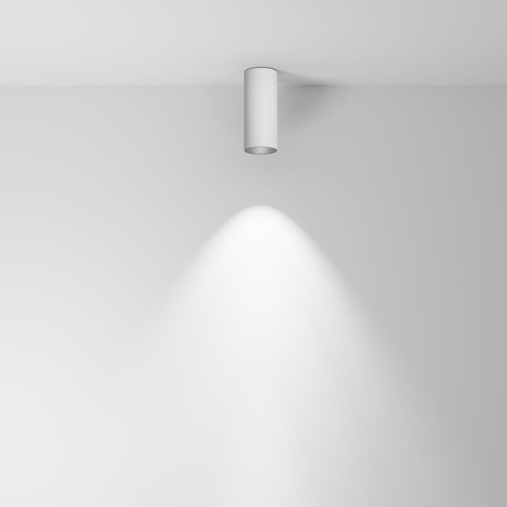 Mise en ambiance : le plafonnier blanc projette un faisceau lumineux sur le mur